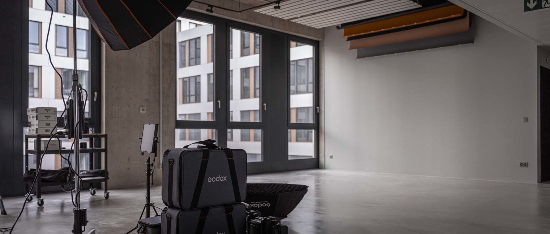 Coin studio avec flight cases et chaise de réalisateur près des fenêtres