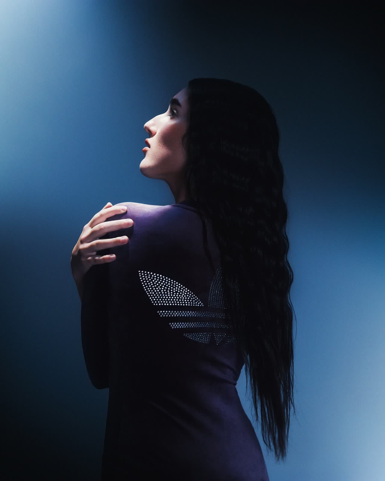 Portrait de profil en robe à sequins sous une lumière bleue