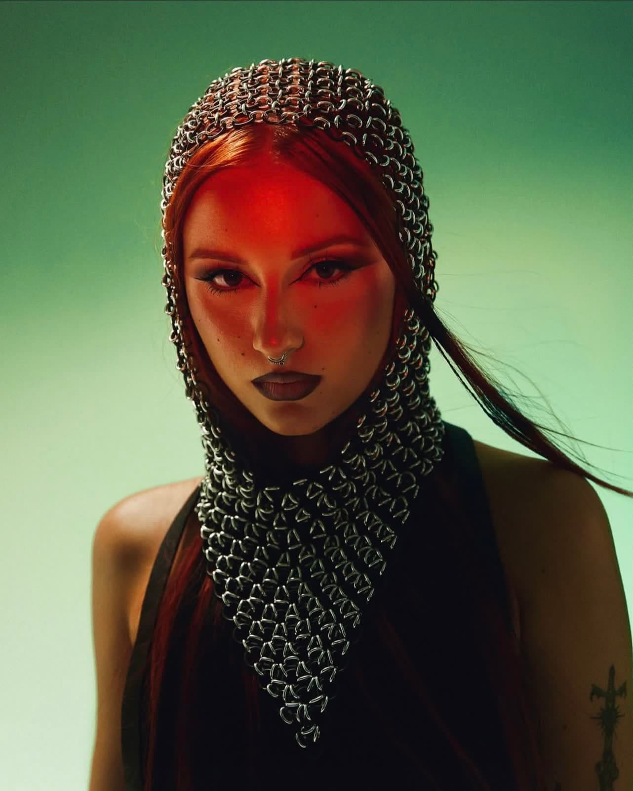Portrait in a chainmail hood on a green backdrop