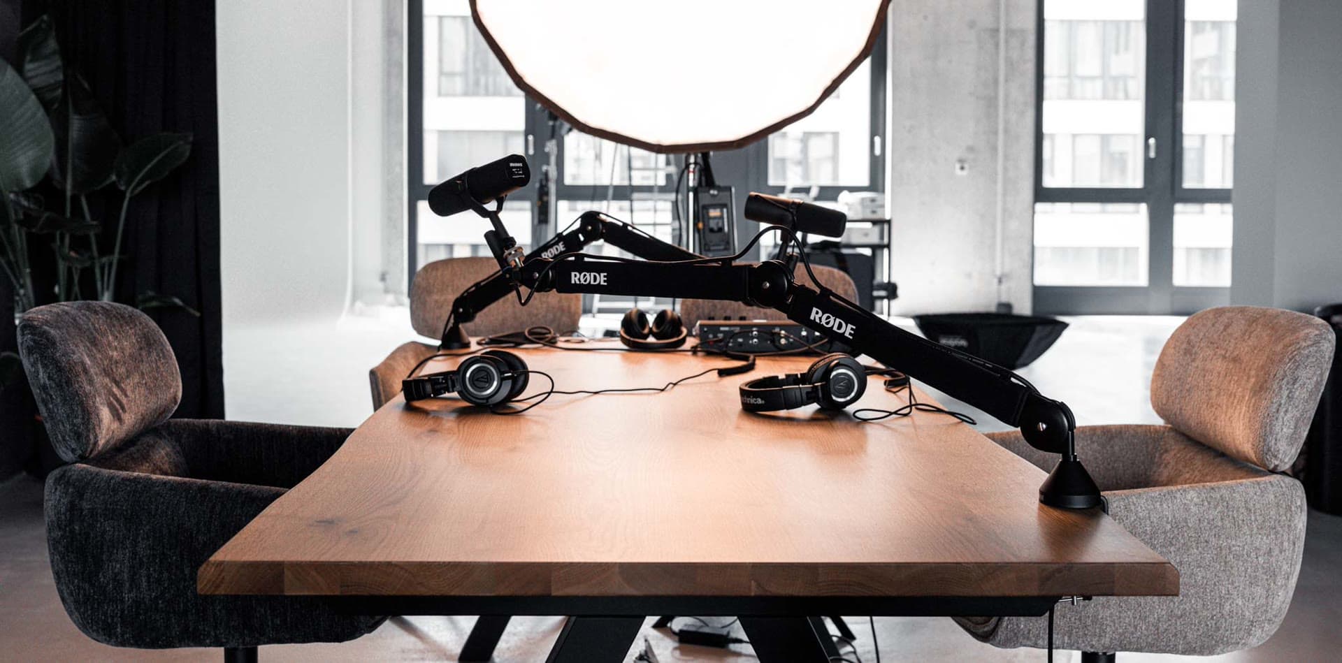 Plateau podcast en lumière du jour, micros sur bras près des fenêtres