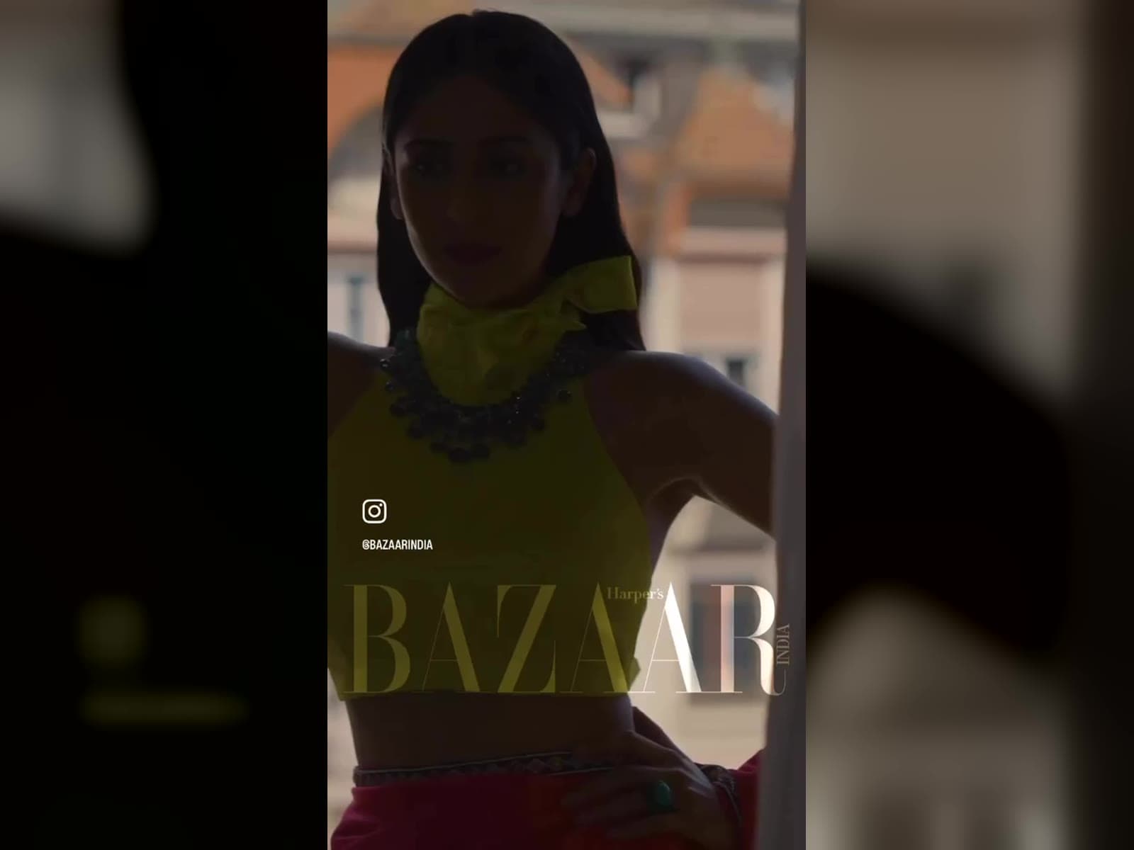 Model in an olive halter top with a statement necklace, Geneva rooftops behind