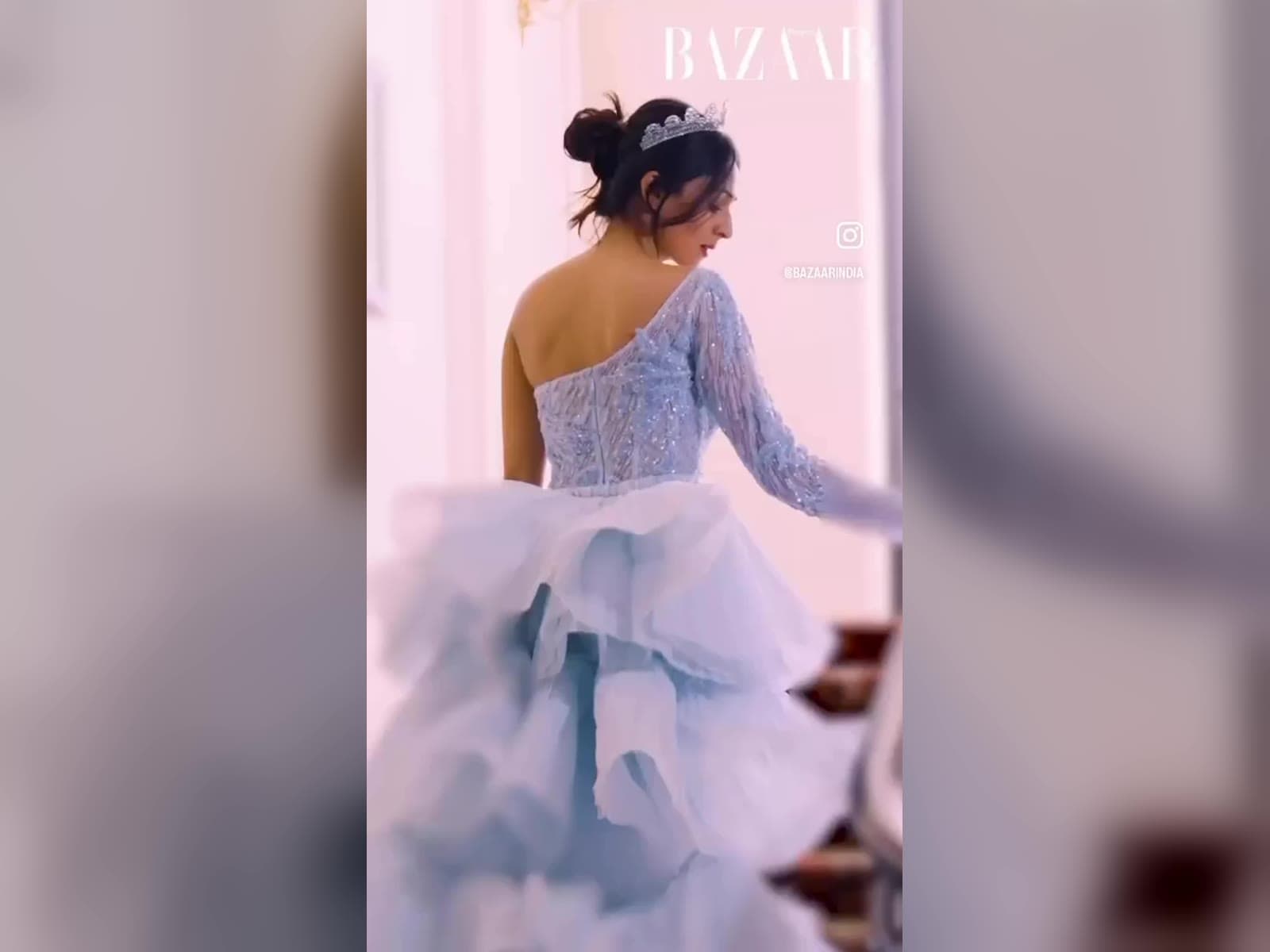Model in a light blue tulle gown and a tiara in a hotel room