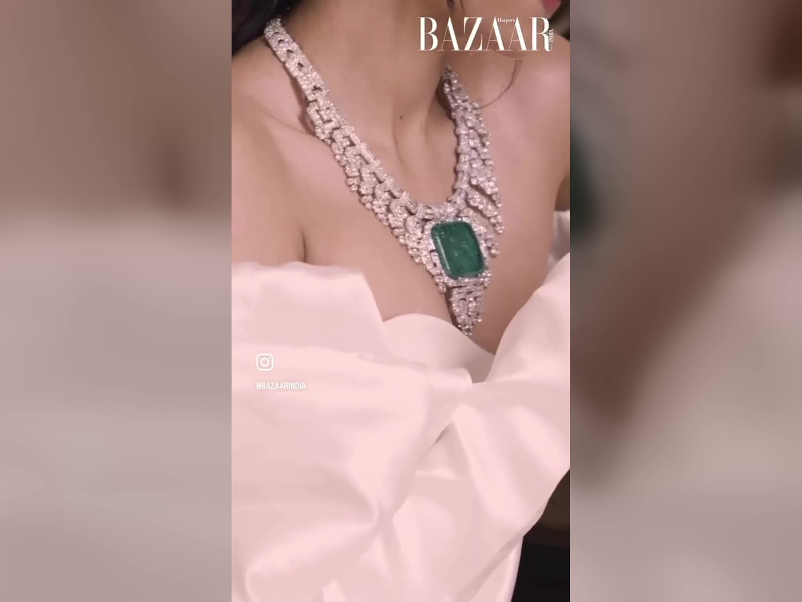 Diamond necklace with an emerald pendant on a pink gown, shot in macro