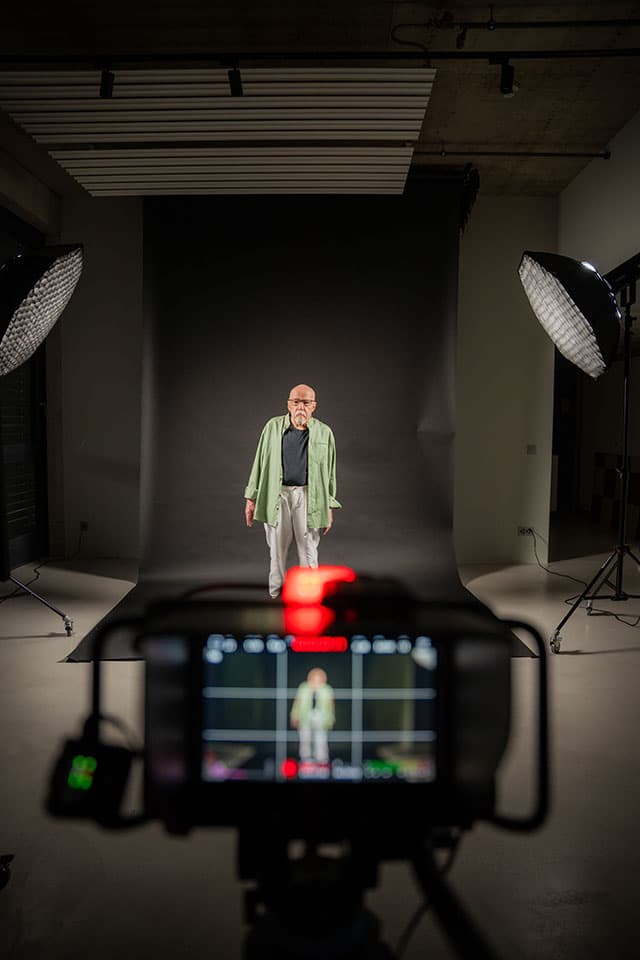 Wide view of the studio set: Paolo Coelho between two softboxes, camera rig in the foreground