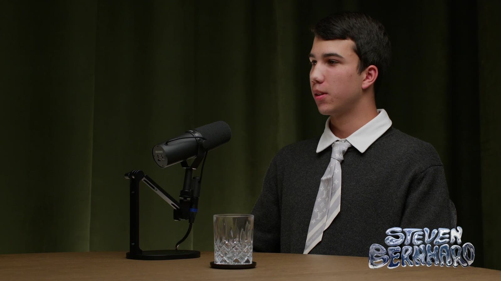 Guest at the microphone on the green velvet set