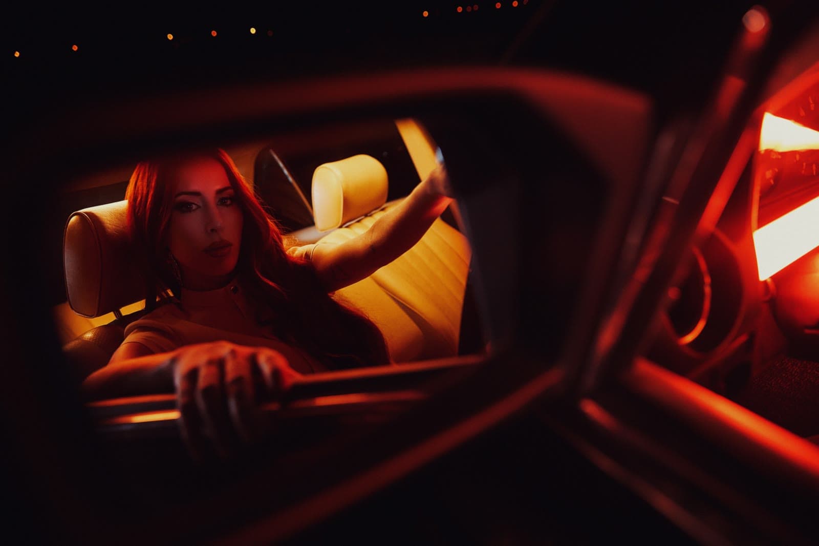 Femme à l'arrière d'une voiture sous une lumière néon rouge