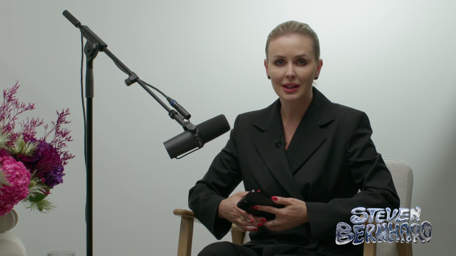 Guest on the white set with flowers beside the microphone