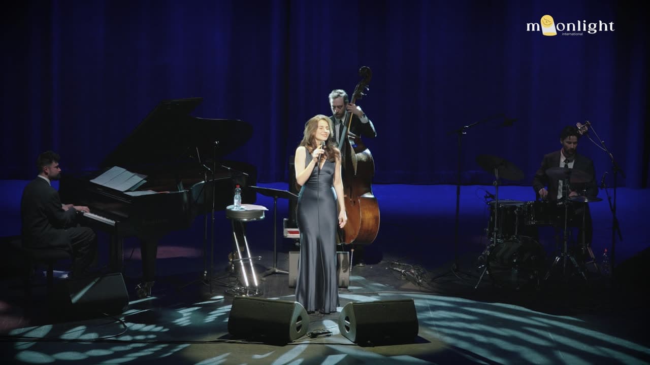 Chanteuse sur une scène bleutée à côté d'un piano à queue